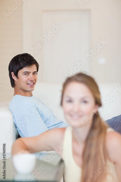 Fototapeta Portrait of a woman having a tea while her fiance is sitting on