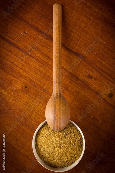 Fototapeta Yellow spice in a wooden bowl