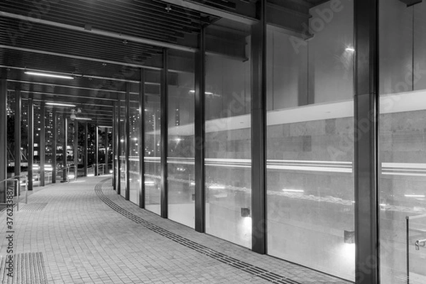 Fototapeta Empty modern pedestrian walkway in midtown at night