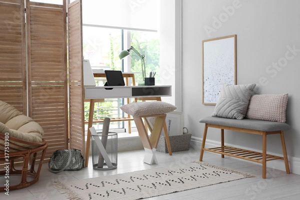 Fototapeta Stylish room interior with comfortable workplace near window