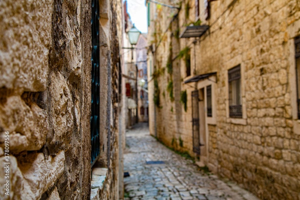 Fototapeta Calle estrecha medieval con detalle enfocado en ventana y desenfoque general