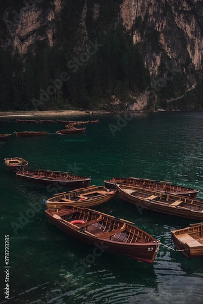 Fototapeta romantic place with brown wooden boats stand on the azure water on the alpine lake Lago di Braies. Dolomites, South Tyrol, Italy, Europe. italian alps.