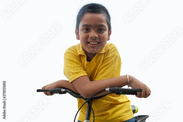 Fototapeta Portrait of confident boy With bicycle	