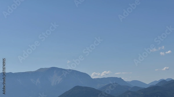 Fototapeta weiter Hotizont mit blauem Himmen, Hügeln und Bergen, die im Dunst verschwinden als Hintergrund