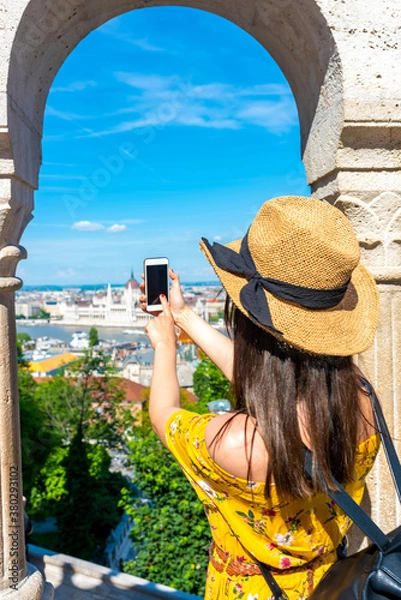 Fototapeta A young woman taking pictures of Budapest