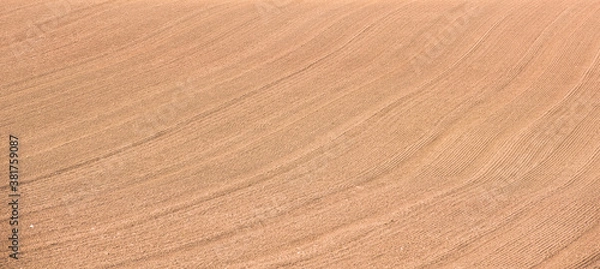 Fototapeta Rows of soil before planting.Furrows row pattern in a plowed field prepared for planting crops in spring