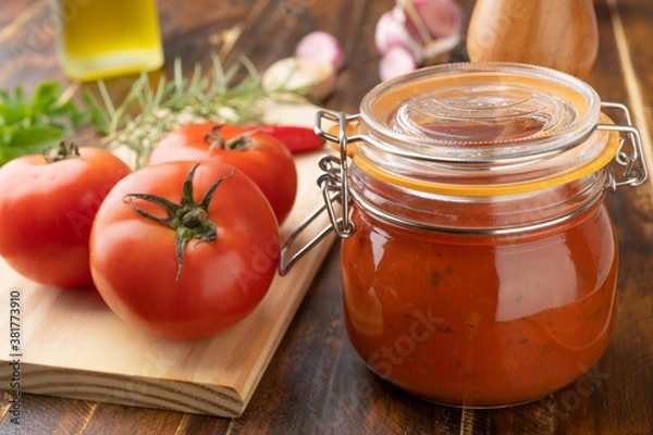 Fototapeta Tomatoes, tomato sauce, garlic, peppers and herbs over wood table