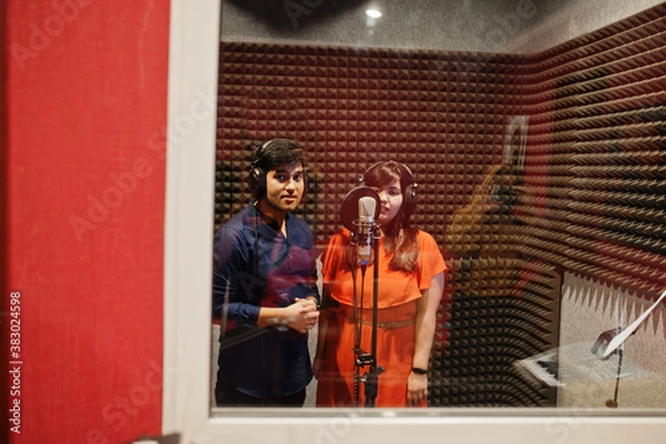 Fototapeta Young asian duet singers with microphone recording song in record music studio.