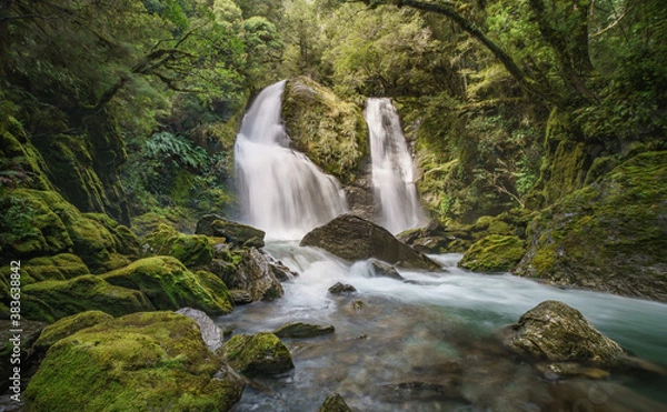 Fototapeta Epic waterfall in lush green mossy forest. Stewart Falls New Zealand