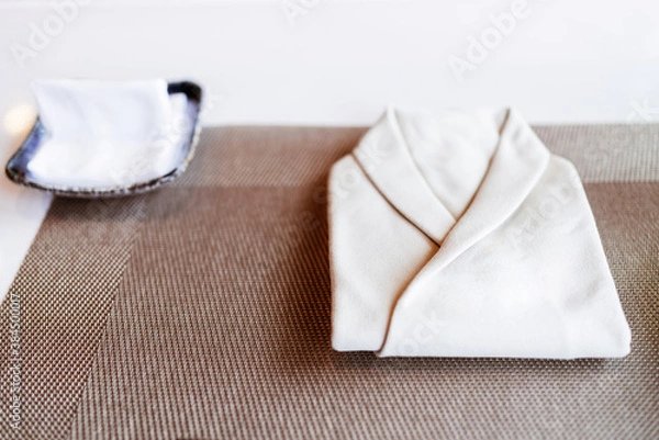 Fototapeta The folded white napkin in Omakase chef uniform shape with finger napkin on the Omakase counter bar.