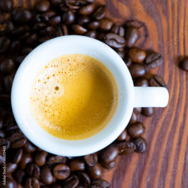 Fototapeta Overhead view of a freshly brewed mug of espresso coffee on rustic wooden background with woodgrain texture