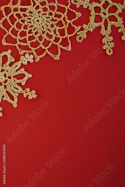 Fototapeta Gold crocheted snowflakes on a red background