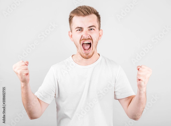 Fototapeta Young man celebrating victory over gray background