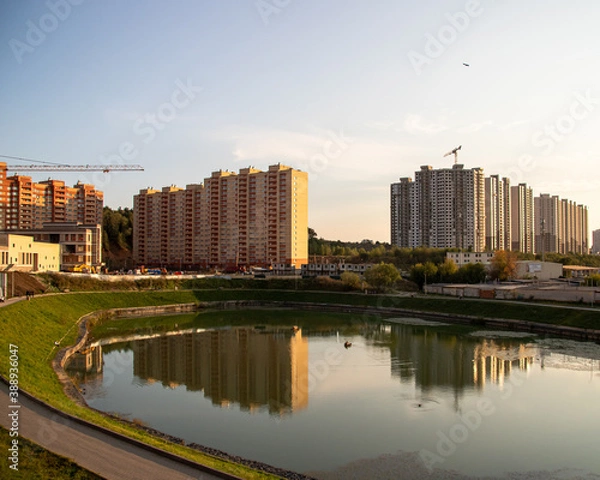 Fototapeta city ​​pond near high-rise buildings construction