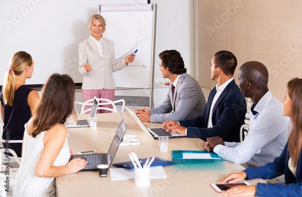 Fototapeta Business woman making presentation on staff meeting at office