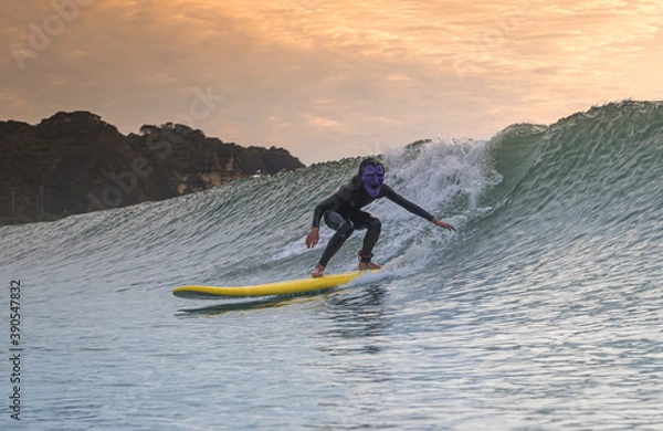 Fototapeta Halloween Costume Surfing Various scary costumes worn by a surfer while riding waves in Japan. Pumpkin, Monster, clown, witch. The waves are clean with a good looking sunrise as well