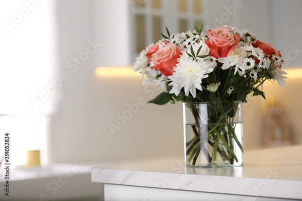 Fototapeta Vase with beautiful flowers on table in kitchen, space for text. Interior design