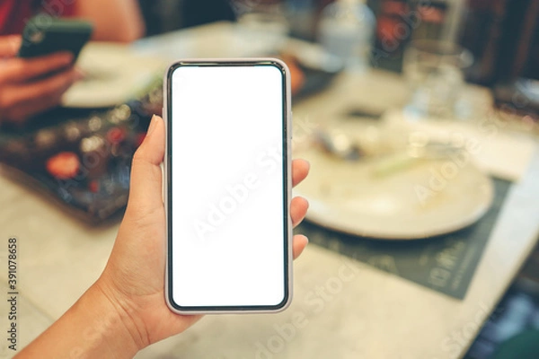 Fototapeta Women's hands holding cell telephone blank copy space screen. smartphone with blank white screen isolated on white background . smart phone with technology concept