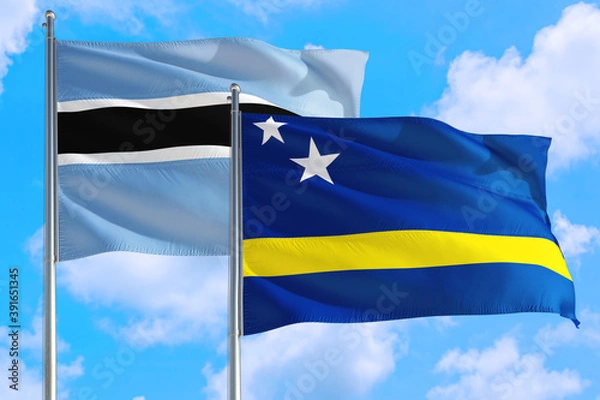 Fototapeta Curacao and Botswana national flag waving in the windy deep blue sky. Diplomacy and international relations concept.