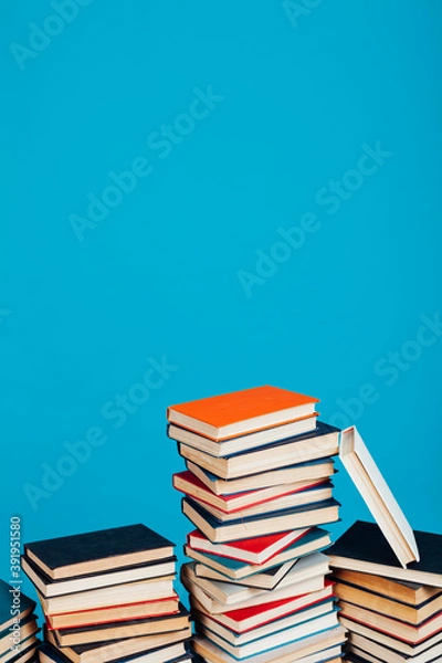 Obraz many stacks of educational books for exams in the library on a blue background