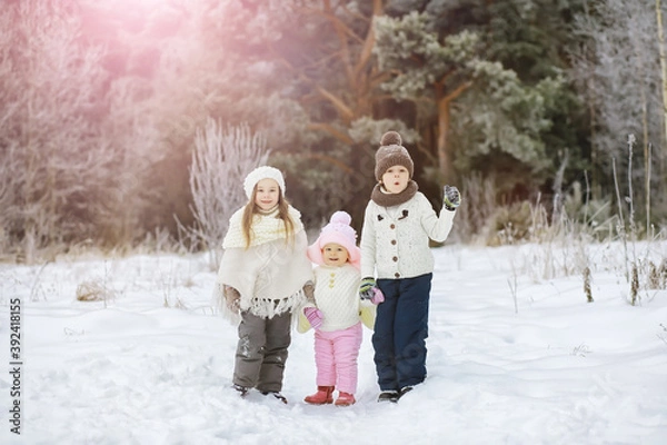 Fototapeta Happy family playing and laughing in winter outdoors in the snow. City park winter day.