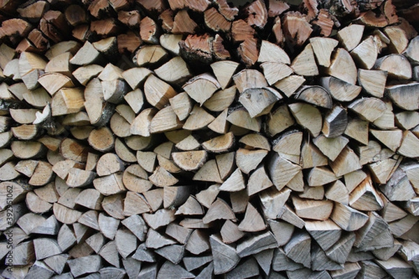 Fototapeta Stacked firewood close-up. Firewood storage. Stocks of wooden logs in the village. Country side lifestyle during winter season.