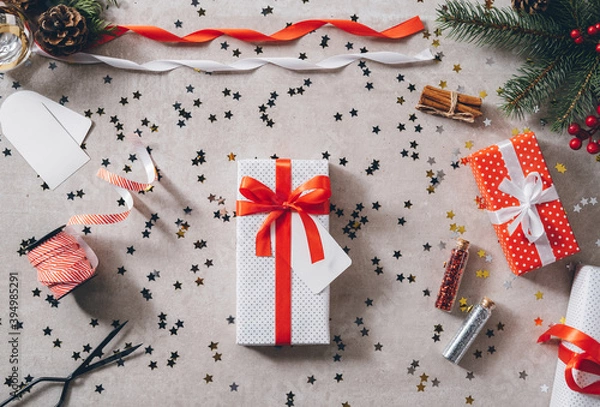 Obraz White present with red ribbon bow on decorated festive table