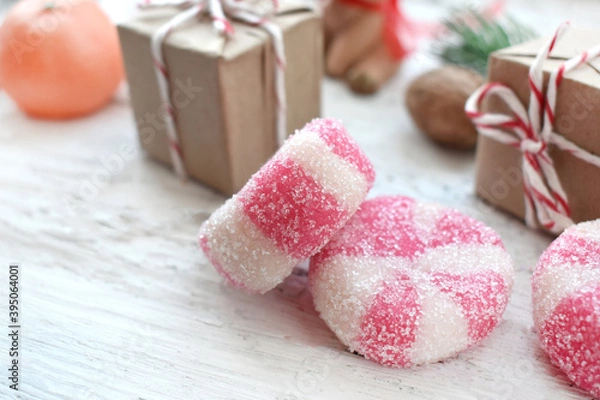 Fototapeta Christmas composition with peppermint candies and gifts on white background. Close up homemade traditional sweets.