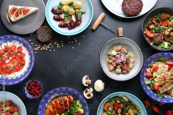 Fototapeta table full of food top view. Set of dishes on the table. meat salad and dessert on table top view