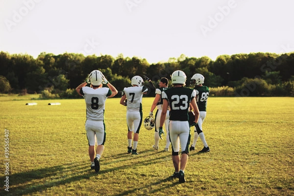 Fototapeta American football team practicing in the late afternoon