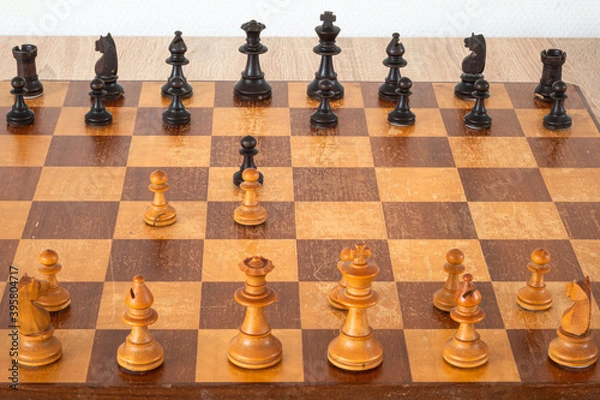 Fototapeta Pieces on a chessboard. The arrangement of the pieces stems from an opening known as Queen's Gambit.