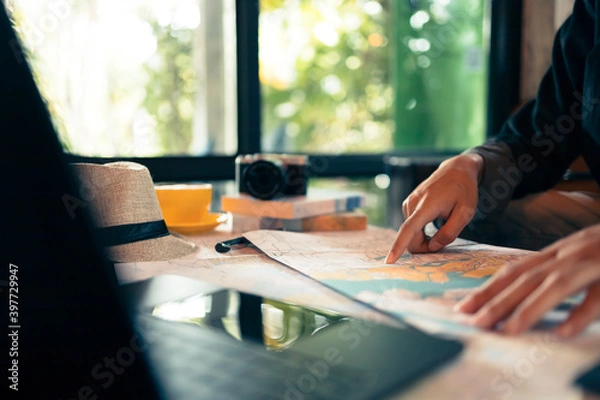 Fototapeta Tourist planning vacation with map and other travel accessories on the table. Travel, holiday, vocation concept.