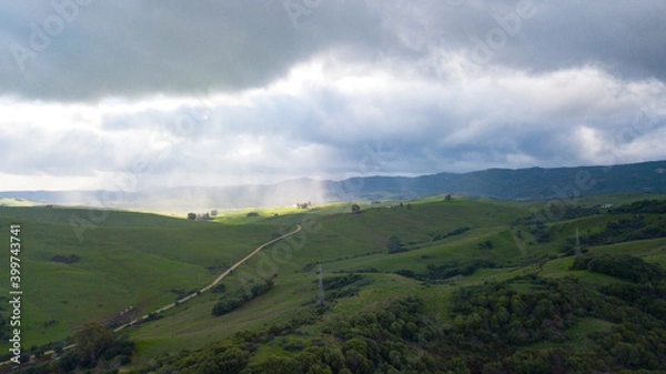 Fototapeta beautiful aerial view of sunlight filtered by clouds in a green natural setting