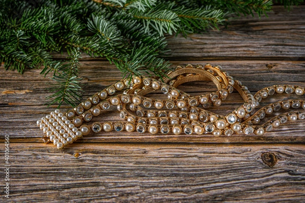 Fototapeta Top view Christmas background with belt of gold, crystal white stones and pearls . Fir tree on wooden table with copy space.