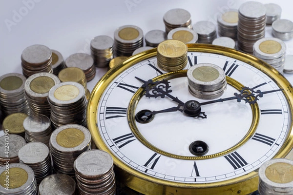 Fototapeta stack of coins on vintage clock