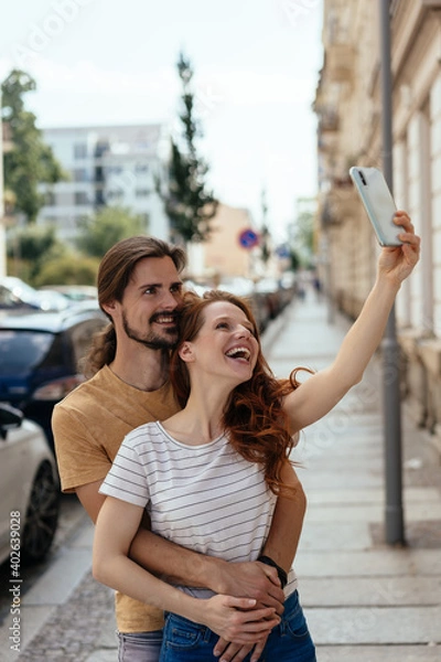 Fototapeta Laughing loving couple taking their selfie