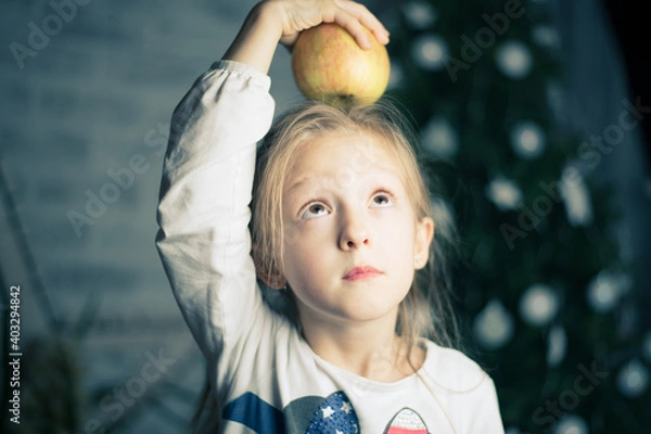 Fototapeta image of a little beautiful girl who is going to eat an apple