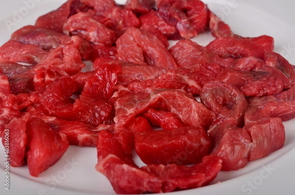 Fototapeta Raw beef meat cut into thin strips for beef Stroganoff on white plate