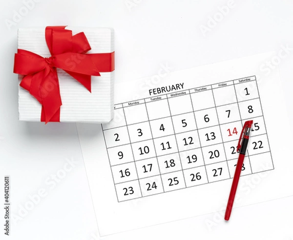 Fototapeta Valentine's day concept. Calendar template with pen and gift box on white background. Flat lay, mockup, top view