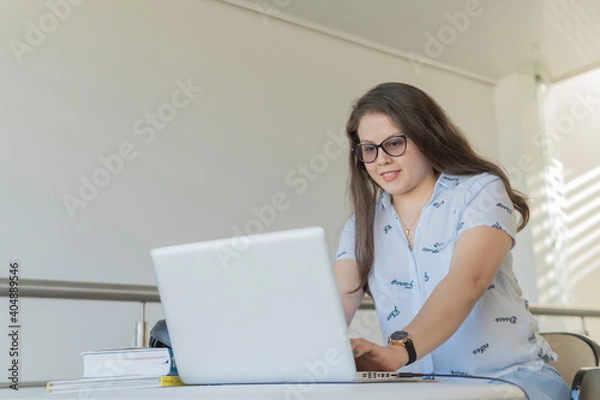 Fototapeta Mujer concentrada y feliz mientras trabaja con su computadora. Concepto trabajo y estudio en casa