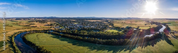 Obraz Amazing river bends among green fields and small town in Australian outback at sunset - wide aerial panorama