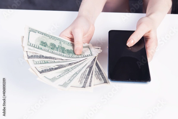 Fototapeta girl holding a phone and money