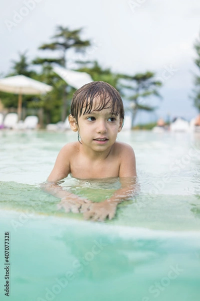 Fototapeta Cute little boy kid child splashing in swimming pool having fun leisure activity