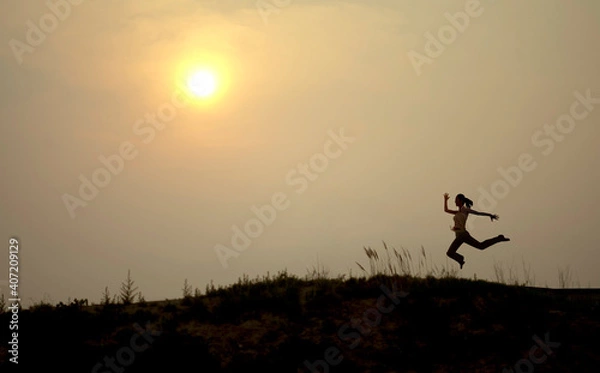 Fototapeta A woman is running silhouette