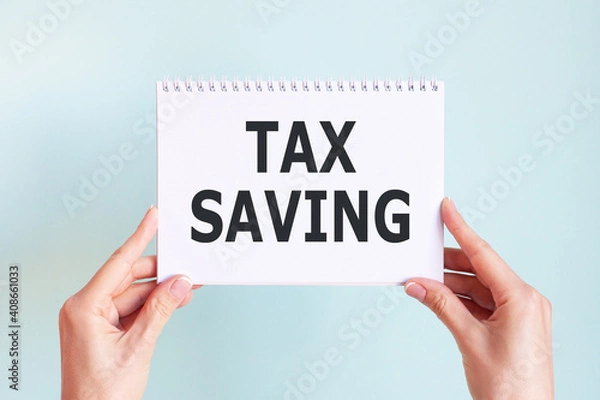 Fototapeta TAX SAVING word inscription on white card paper sheet in hands of a woman. Business concept