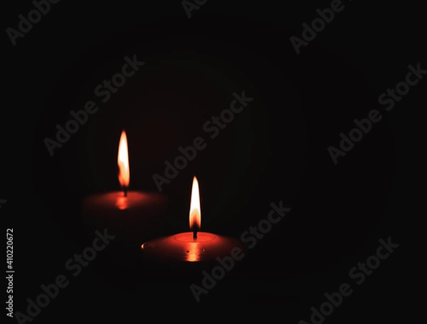 Fototapeta two candles burning in dark