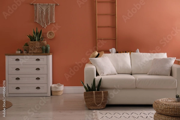 Fototapeta Stylish living room interior with comfortable sofa and potted plants