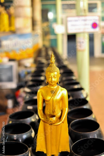 Fototapeta The Standing Buddha image with monk's alms bowls background at Wat Bua Khwan temple Nonthaburi province ,Thailand 