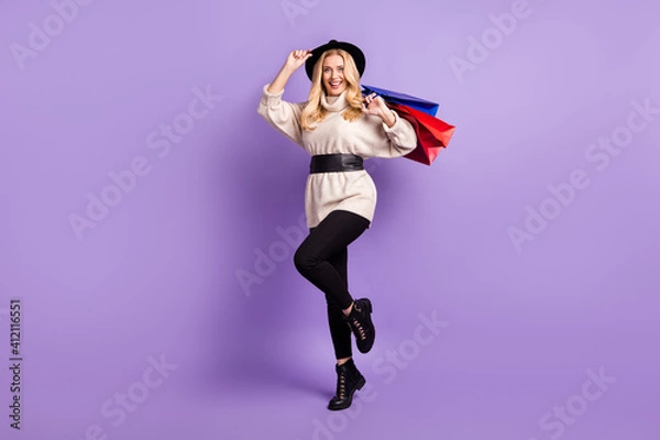 Obraz Full length photo of attractive positive woman wear hat hold shopping bags isolated on purple color background