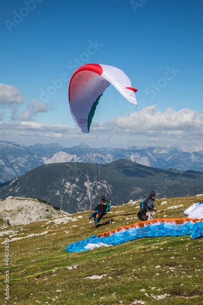 Fototapeta  Austria, Dachstein, Paragliders preparing to take off above Lake Hallstatt and the surrounding mountains, all of which is part of the Salzkammergut Cultural Landscape, UNESCO World Heritage Site